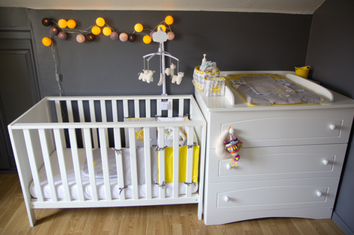 Coin lit et change chambre bébé en jaune, gris, blanc